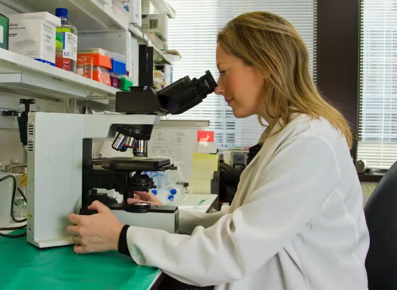 Woman looking through microscope